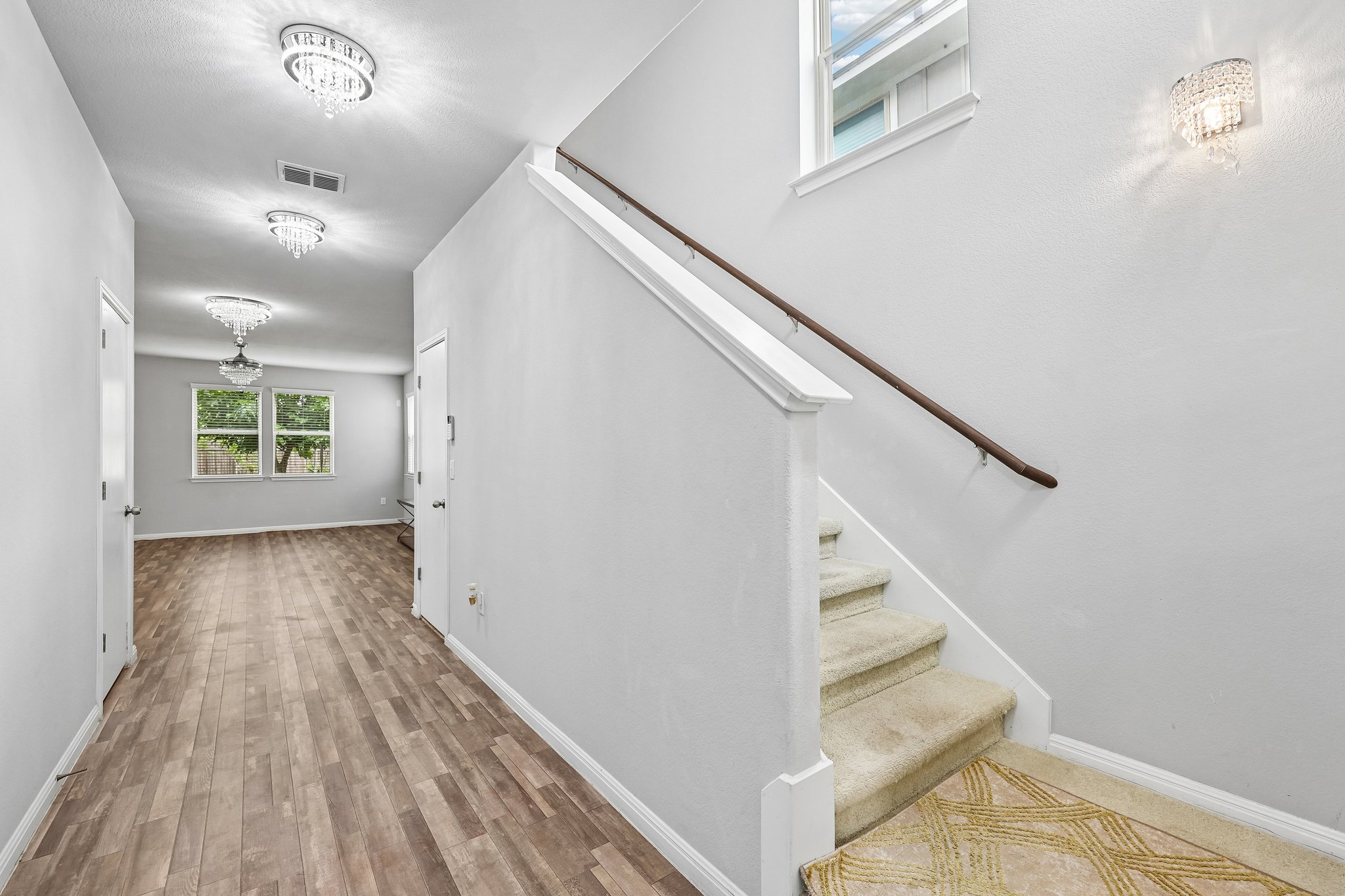 387 Guemal Road Buda, TX 78610 - Photo 16 of 39 Entryway featuring wood-finish flooring, white baseboards, and three decorative flush-mount light fixtures