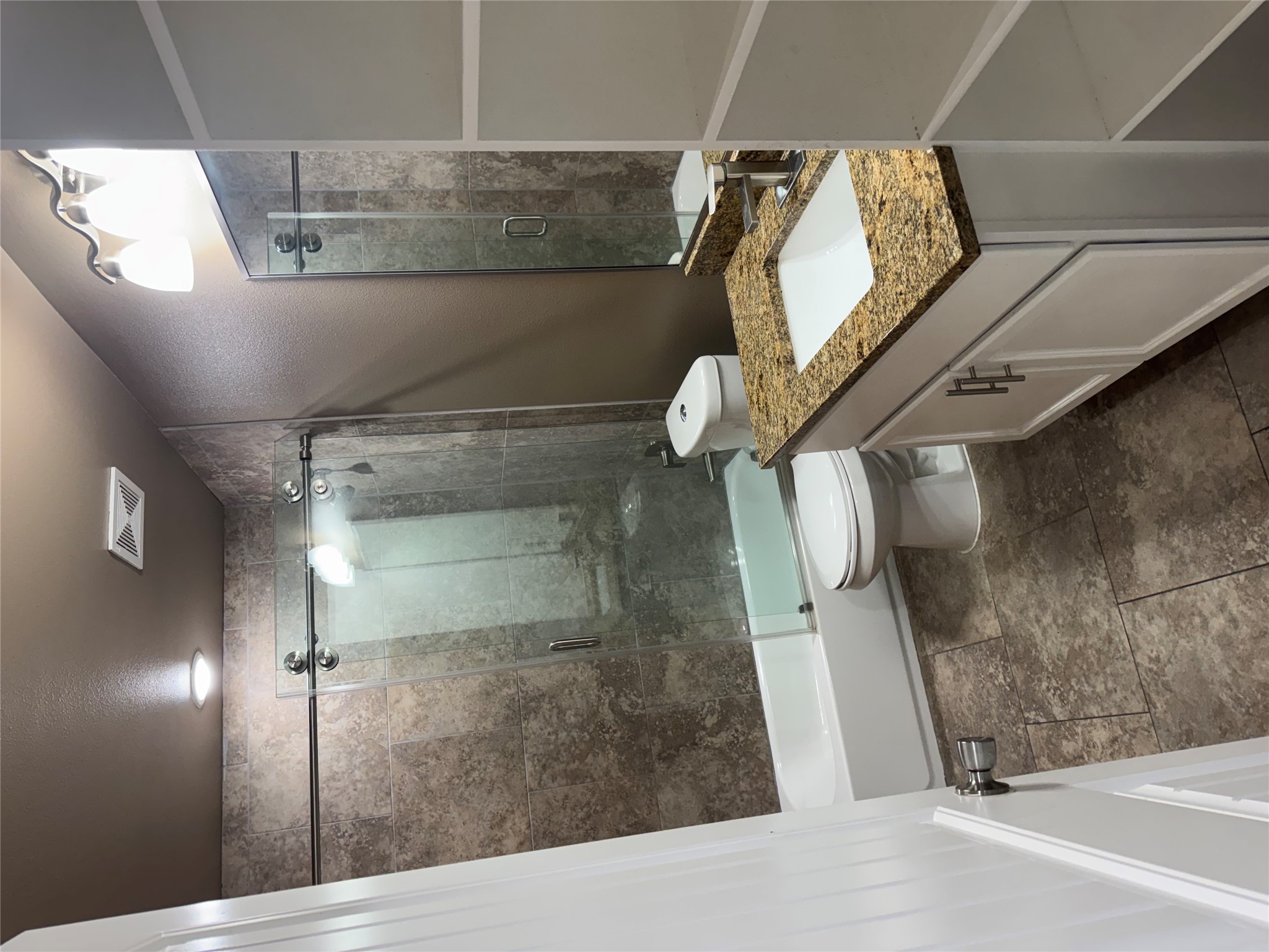 5706 Melody Lane, Unit 2 Austin, TX 78724 - Photo 9 of 13 a bathroom with a granite countertop sink a toilet and shower