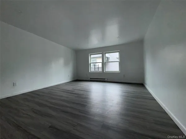 an empty room with wooden floor and window