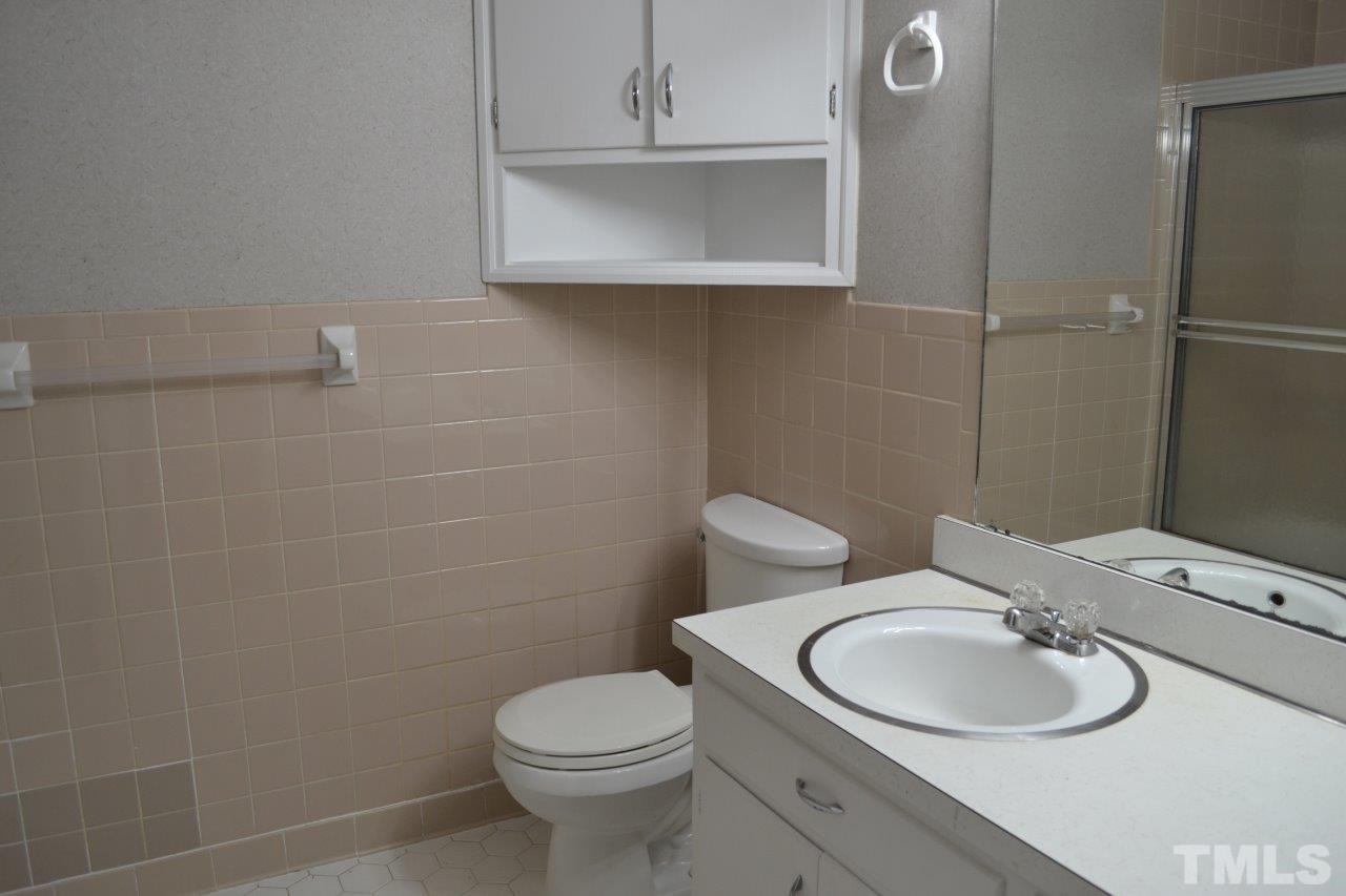 2709 Ramsey Road Raleigh, NC 27604 - Photo 5 of 6 a bathroom with a toilet sink mirror and vanity
