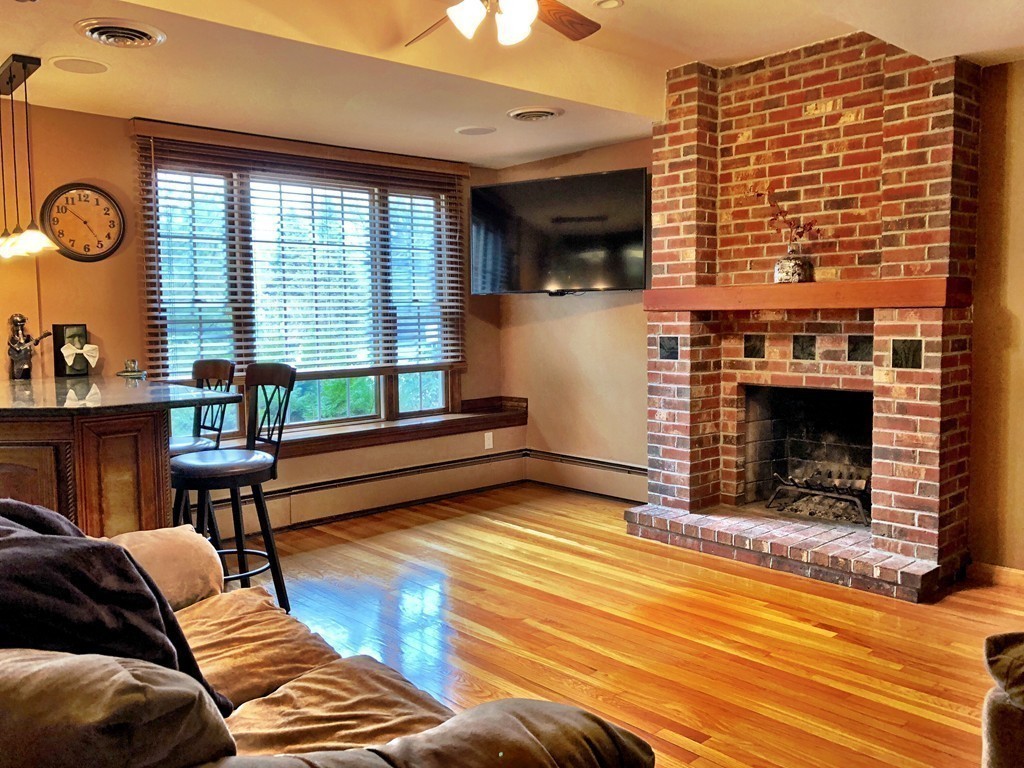 11 Hampton Road Sharon, MA 02067 - Photo 7 of 27 a living room with furniture a fireplace and a flat screen tv