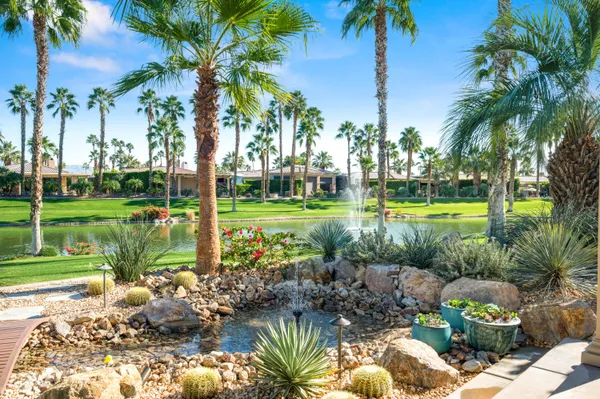a view of a patio with table and chairs potted plants and floor to ceiling window