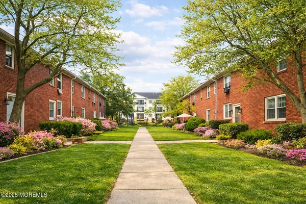 a front view of a house with a yard and potted plants