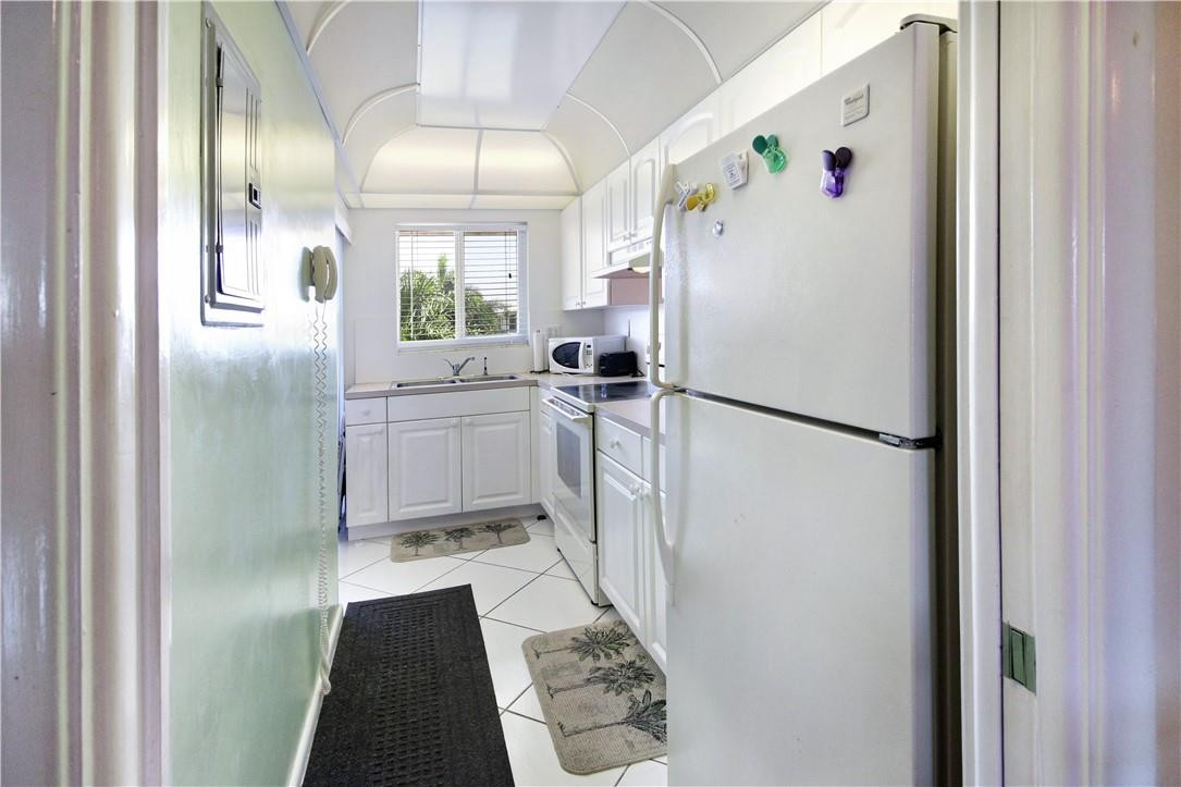 2100 Northeast 38th Street, Unit 222 Lighthouse Point, FL 33064 - Photo 12 of 21 a kitchen with a refrigerator a sink and dishwasher