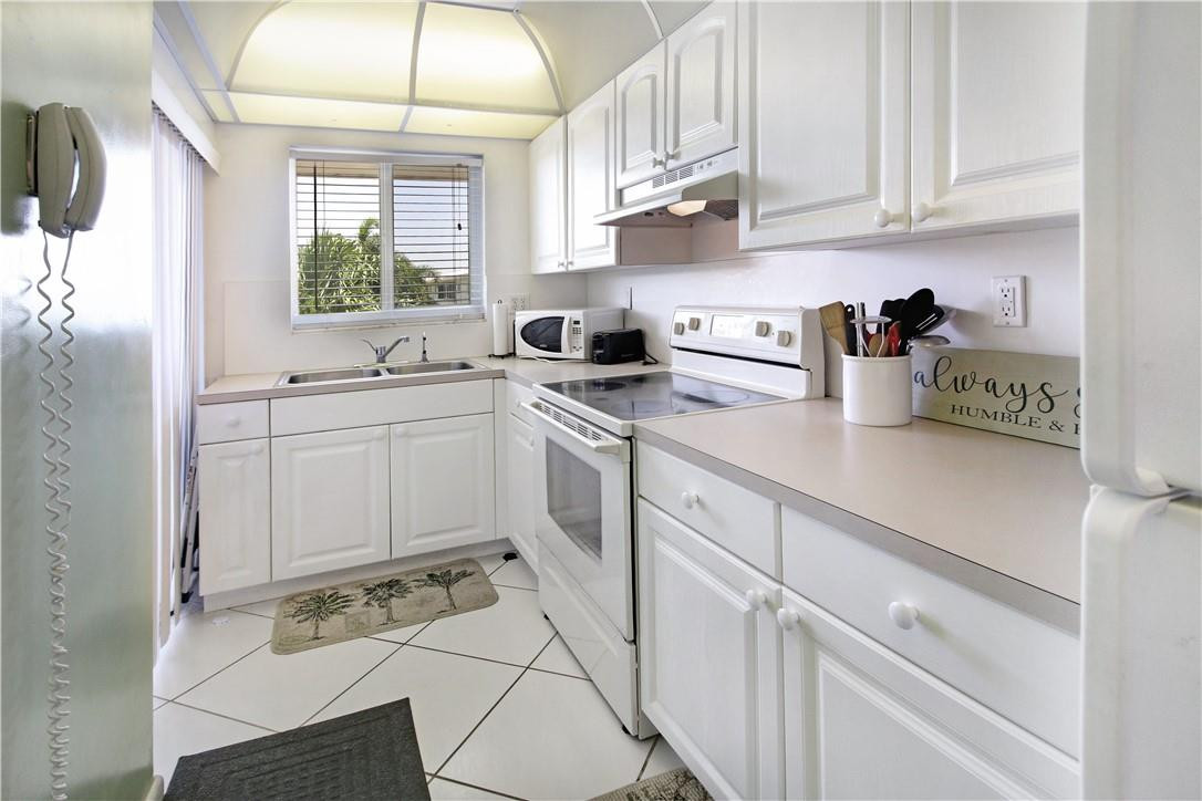 2100 Northeast 38th Street, Unit 222 Lighthouse Point, FL 33064 - Photo 13 of 21 a kitchen with white cabinets and white appliances