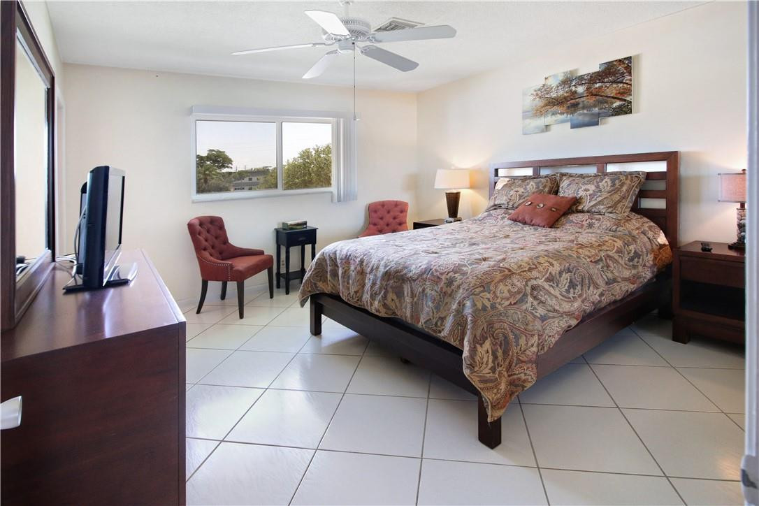 2100 Northeast 38th Street, Unit 222 Lighthouse Point, FL 33064 - Photo 16 of 21 a bedroom with a bed and a desk