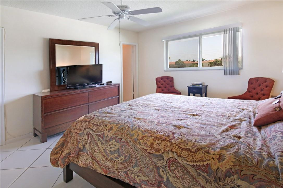 2100 Northeast 38th Street, Unit 222 Lighthouse Point, FL 33064 - Photo 17 of 21 a bedroom with a bed and a flat screen tv