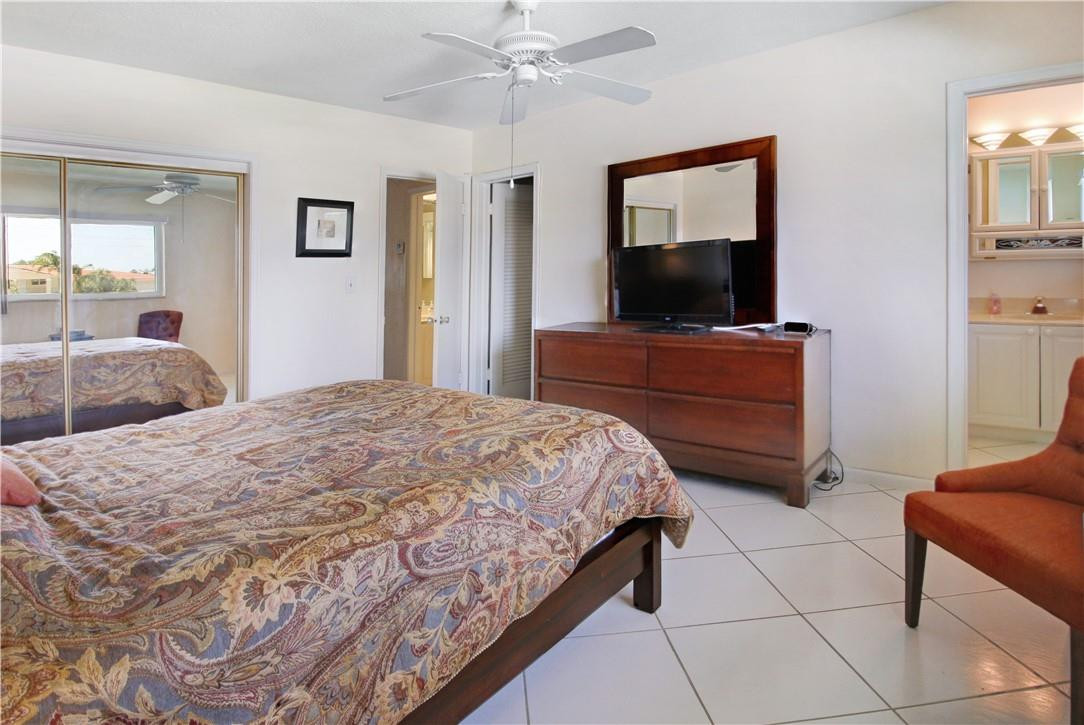 2100 Northeast 38th Street, Unit 222 Lighthouse Point, FL 33064 - Photo 18 of 21 a bedroom with a bed and a flat screen tv