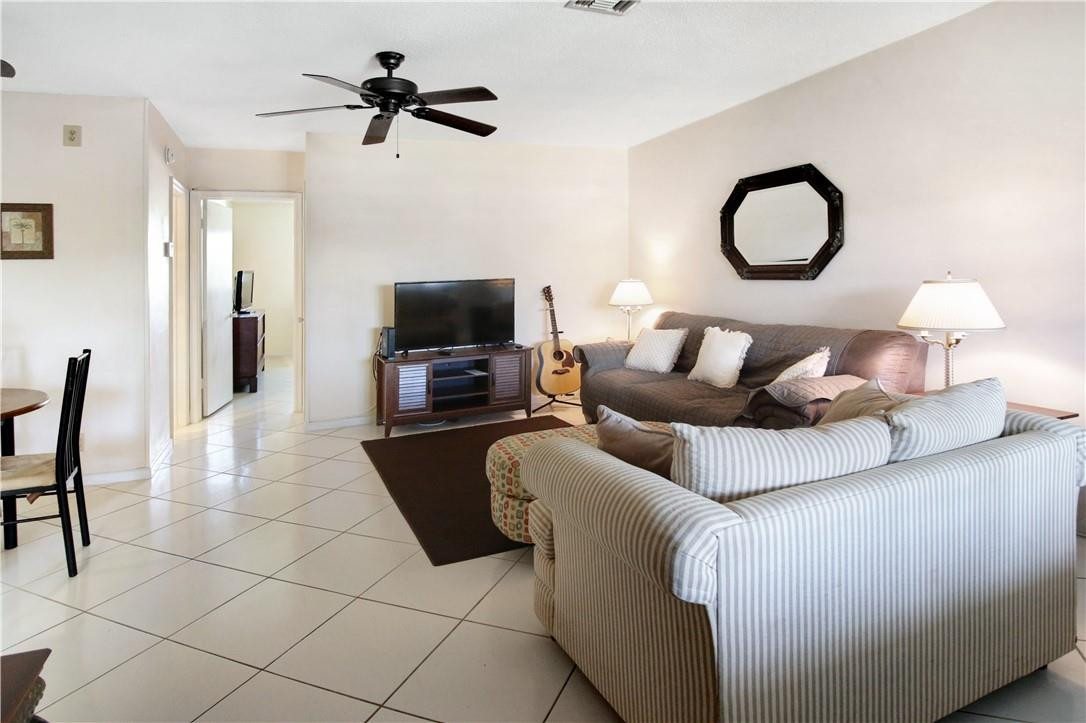 2100 Northeast 38th Street, Unit 222 Lighthouse Point, FL 33064 - Photo 6 of 21 a living room with furniture a flat screen tv and a fireplace
