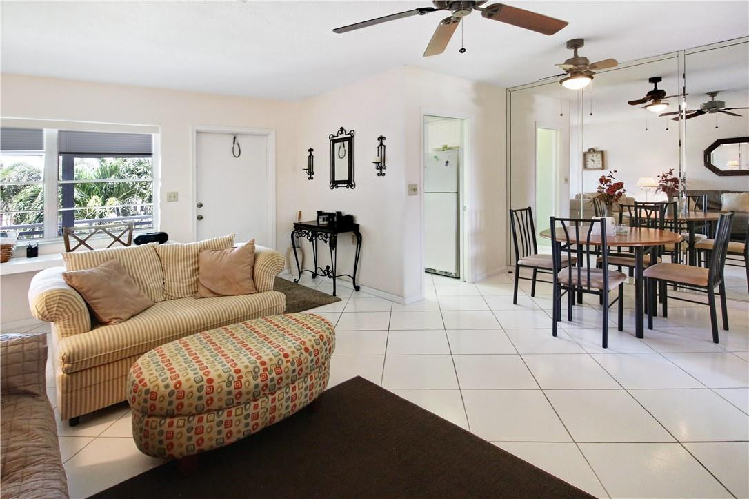 2100 Northeast 38th Street, Unit 222 Lighthouse Point, FL 33064 - Photo 9 of 21 a living room with furniture a dining table and a fireplace