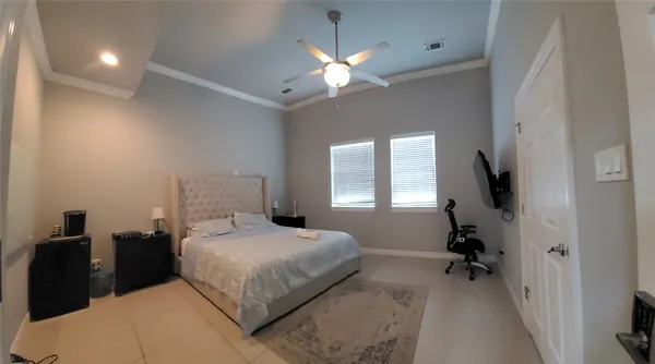a bedroom with a bed and a flat tv screen on wall