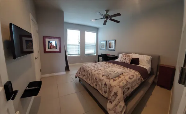 a bedroom with a bed window and a flat screen tv