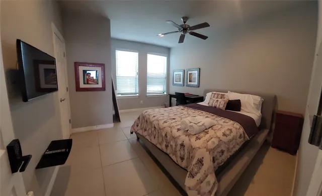 a bedroom with a bed window and a flat screen tv