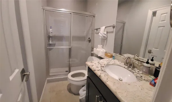a bathroom with a granite countertop sink toilet and shower