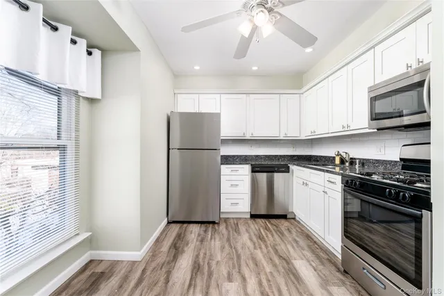 a kitchen with a refrigerator and a stove top oven