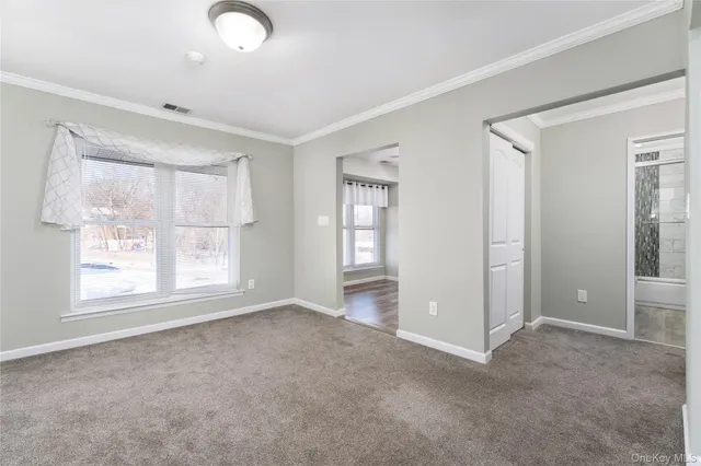 an empty room with windows and closet
