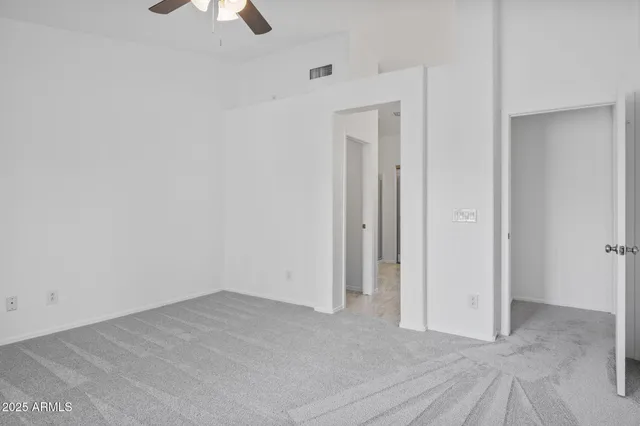 a view of a livingroom with a furniture a ceiling fan and window