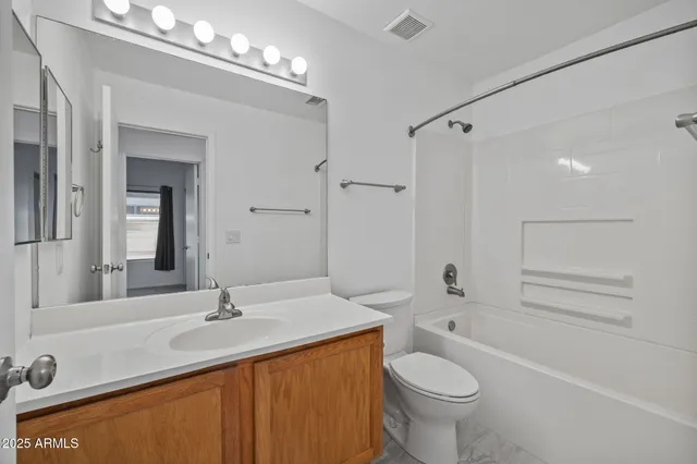 a spacious bathroom with double vanity and a tub