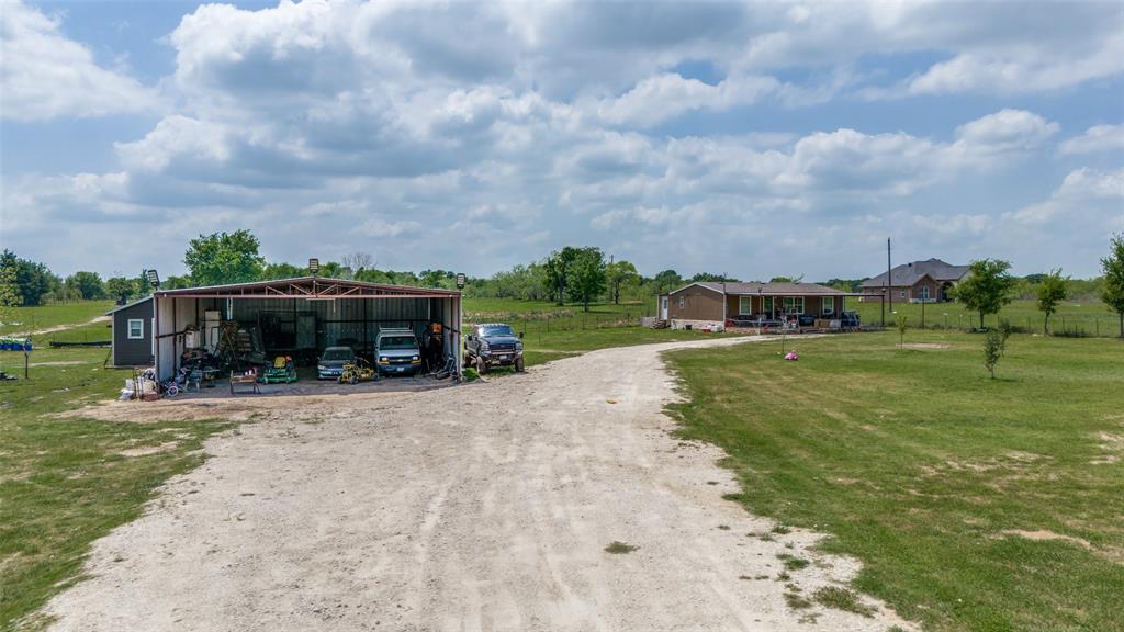 266 Fcr 1031 Wortham, TX 76693 - Photo 3 of 10 Manufactured / mobile home featuring a pole building, a view of countryside, an outdoor structure, and a front lawn