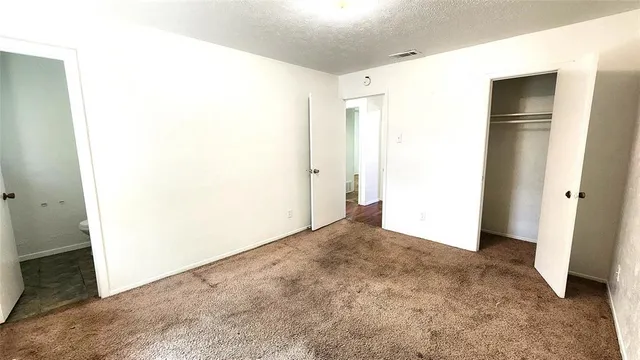 a bathroom with a granite countertop toilet sink and mirror