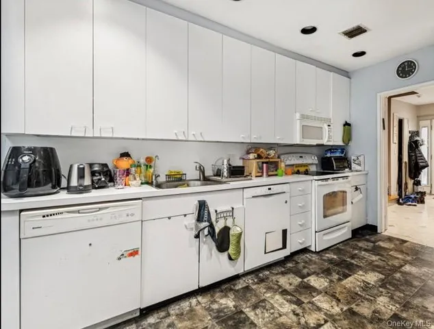 a kitchen with stainless steel appliances granite countertop white cabinets and white appliances