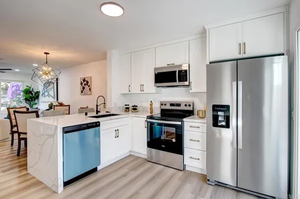a kitchen with stainless steel appliances a refrigerator stove microwave and sink