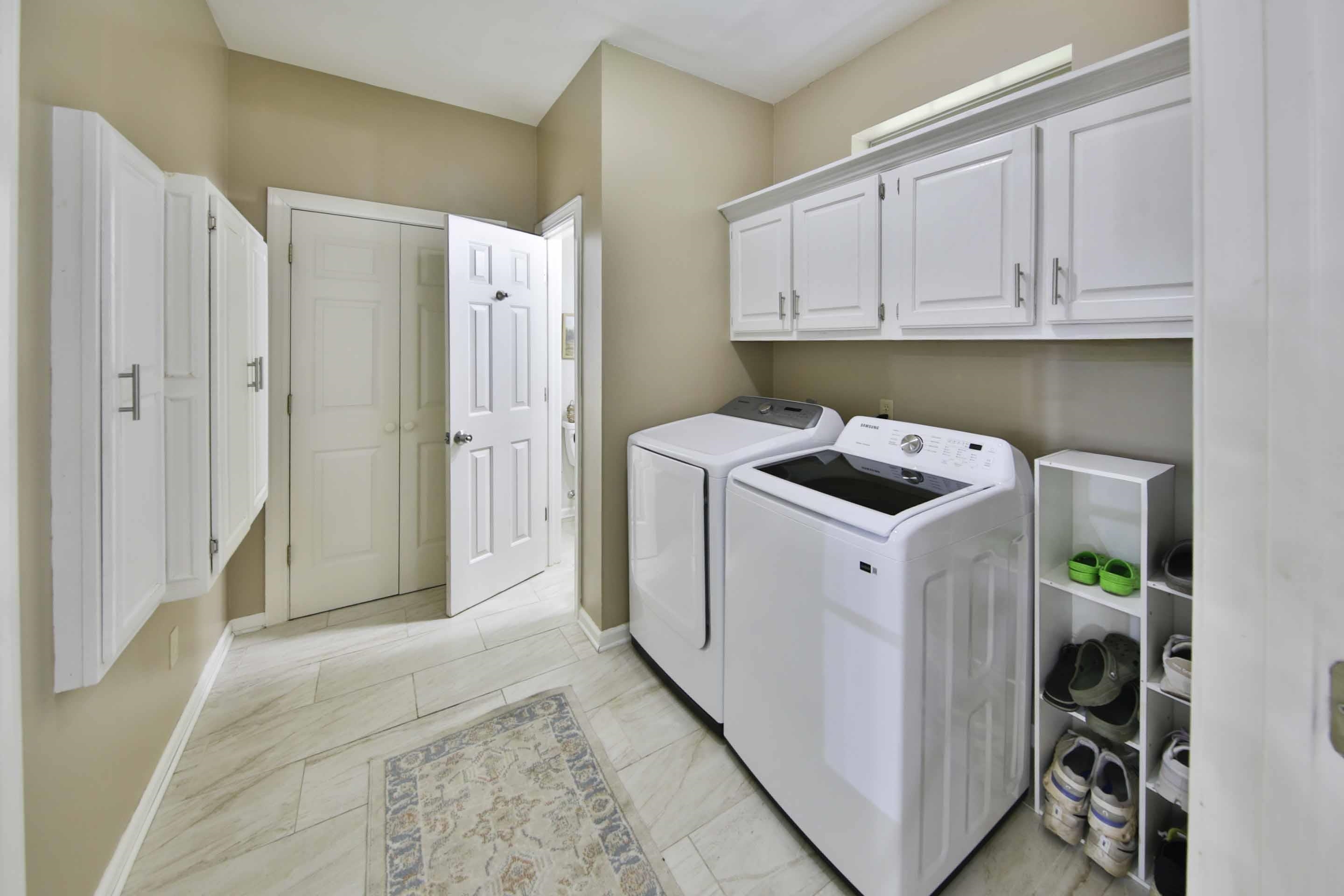 104 Miller Road Covington, TN 38019 - Photo 14 of 25 Bright laundry area featuring light tone wall paint and white shaker-style cabinetry with silver hardware