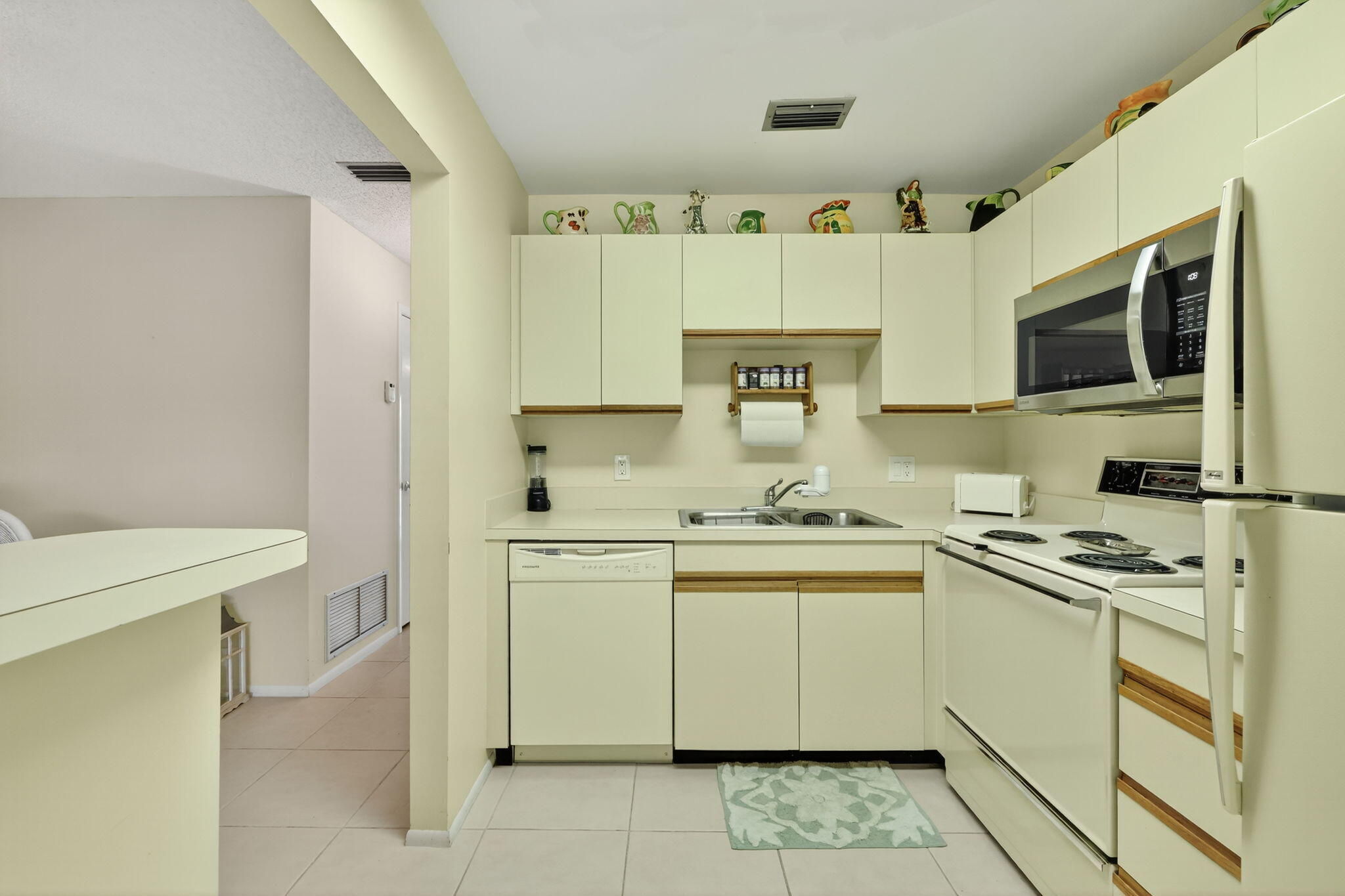 23 Lake Vista Trail, Unit 204 Port St. Lucie, FL 34952 - Photo 12 of 35 a kitchen with stainless steel appliances a stove sink microwave and cabinets
