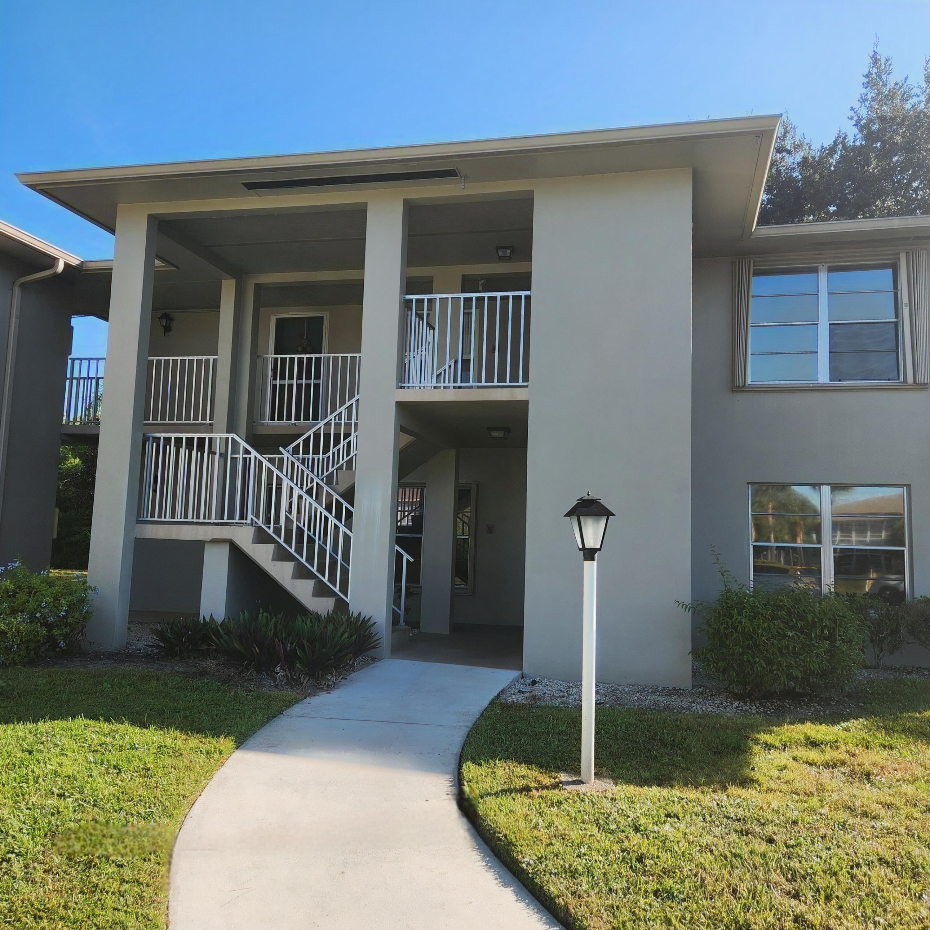 23 Lake Vista Trail, Unit 204 Port St. Lucie, FL 34952 - Photo 33 of 35 a front view of a house with a yard