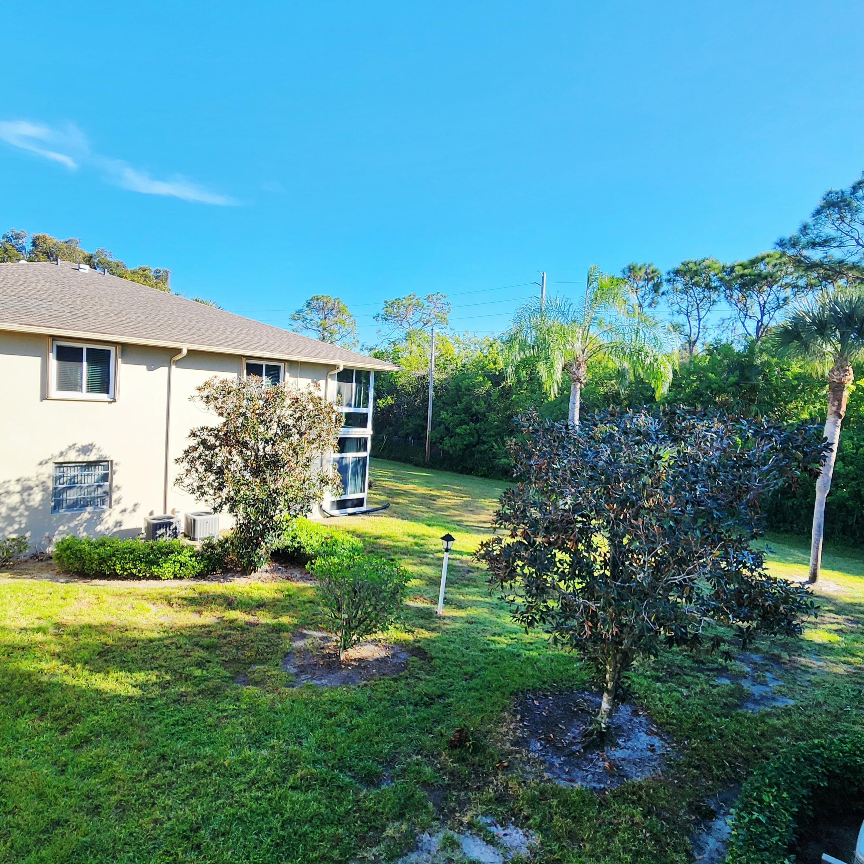 23 Lake Vista Trail, Unit 204 Port St. Lucie, FL 34952 - Photo 5 of 35 a view of a house with a yard and potted plants