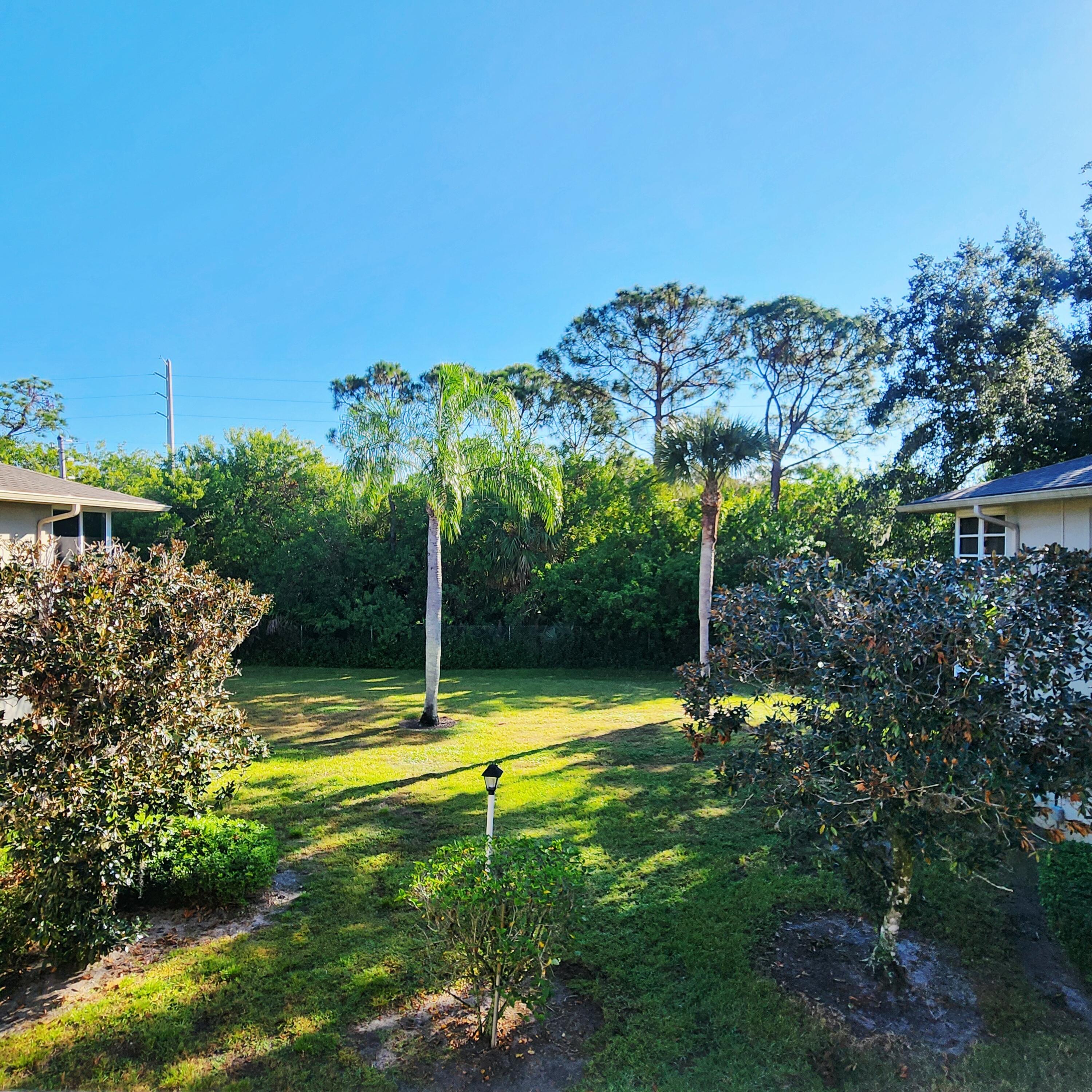 23 Lake Vista Trail, Unit 204 Port St. Lucie, FL 34952 - Photo 6 of 35 a view of a swimming pool with a yard and large trees