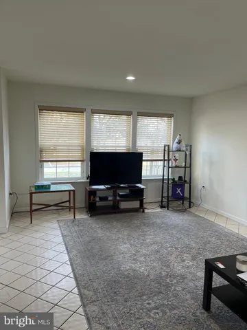 a living room with furniture a window and a flat screen tv