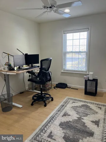 a view of a workspace with furniture and a window