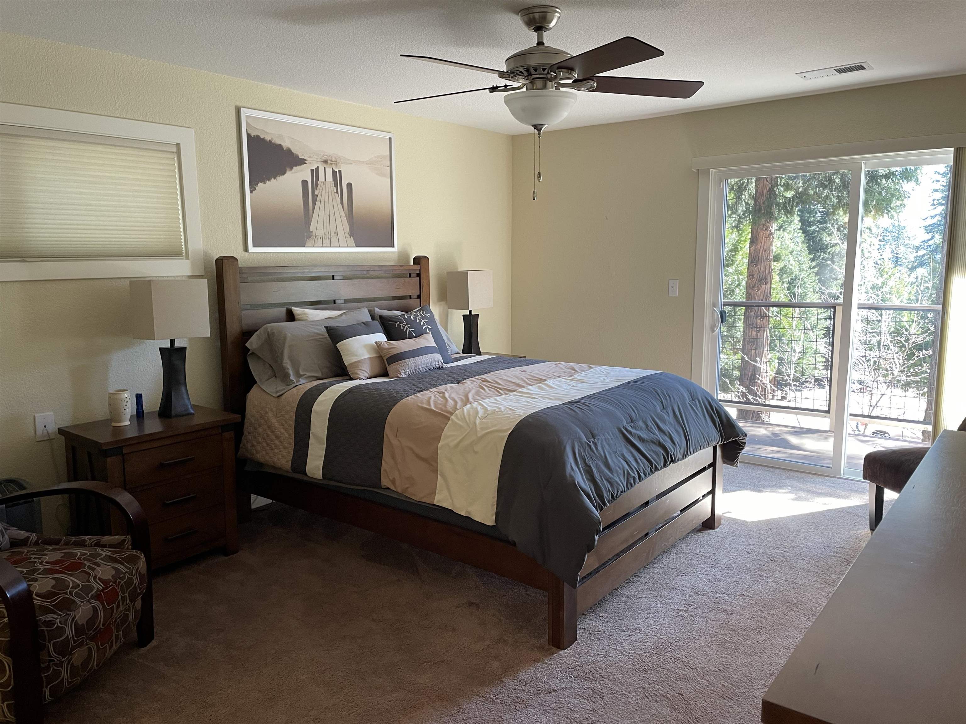 831 Timber Ridge Road Lake Almanor, CA 96137 - Photo 14 of 36 a bedroom with a bed lamp and a large window