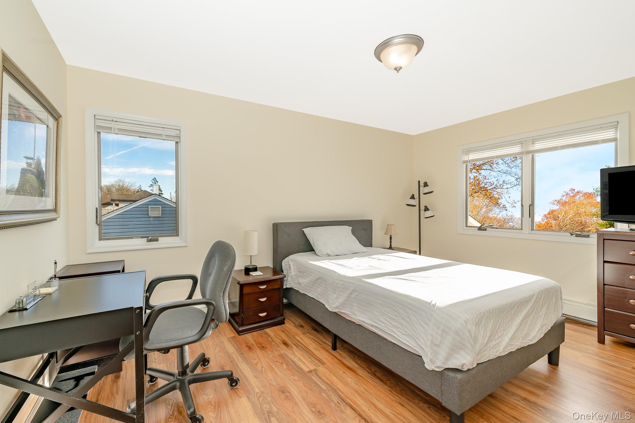 15 Chadwick Road Syosset, NY 11791 - Photo 13 of 35 a bedroom with a bed a desk and chair with wooden floor