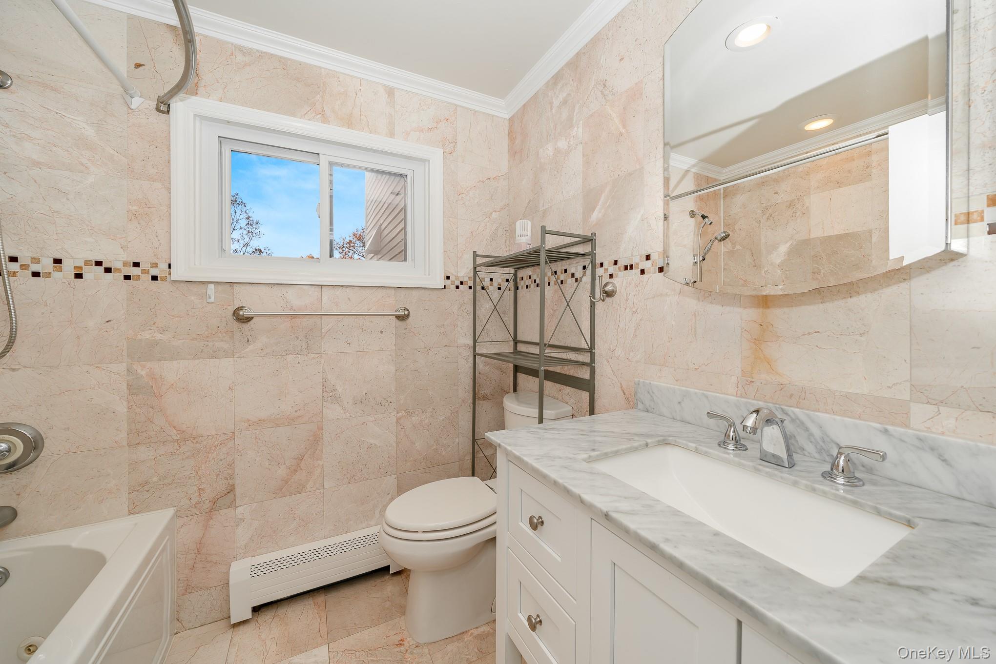 15 Chadwick Road Syosset, NY 11791 - Photo 24 of 35 a bathroom with a granite countertop sink a toilet and a bathtub