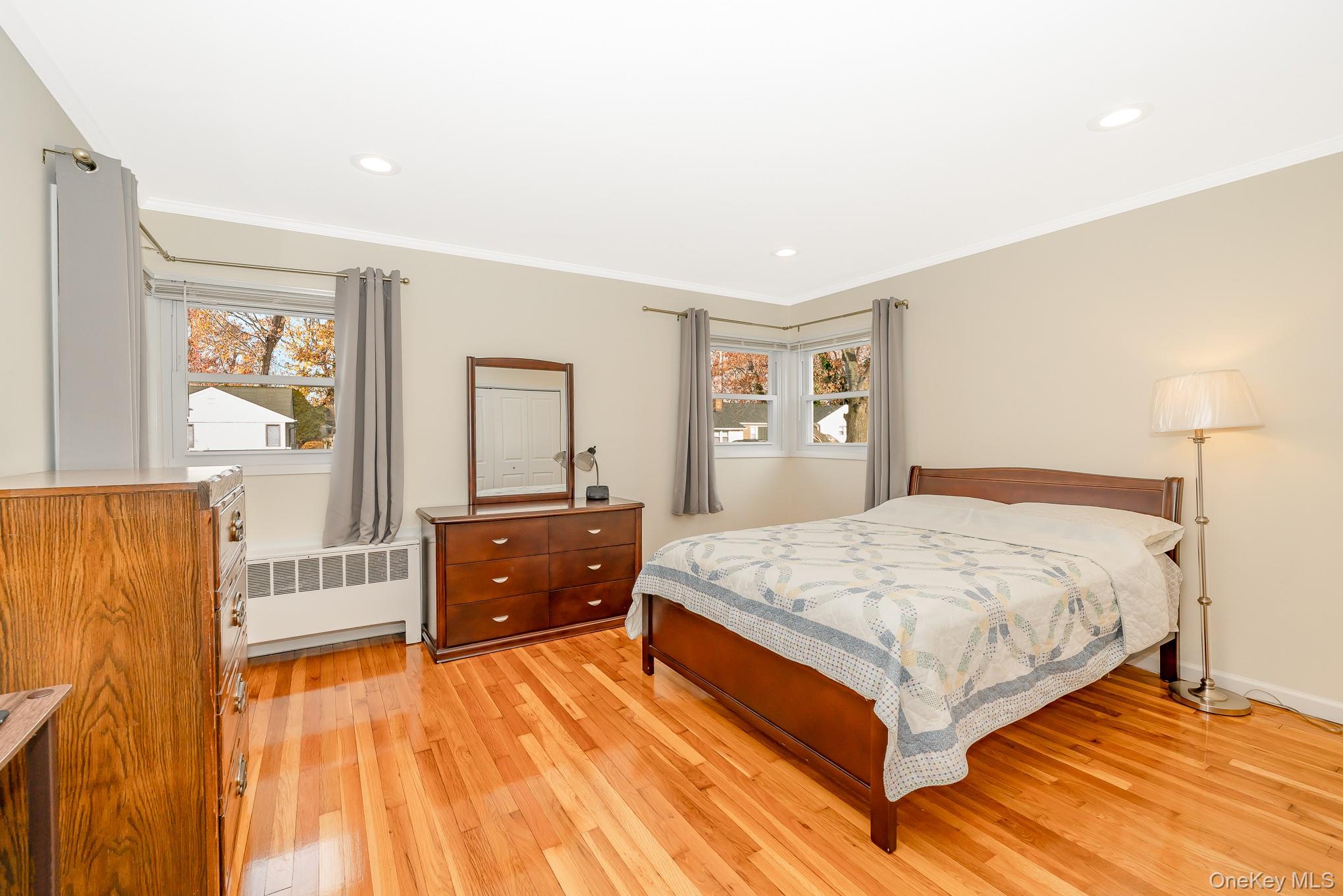 15 Chadwick Road Syosset, NY 11791 - Photo 25 of 35 a bedroom with a bed and dresser with wooden floor
