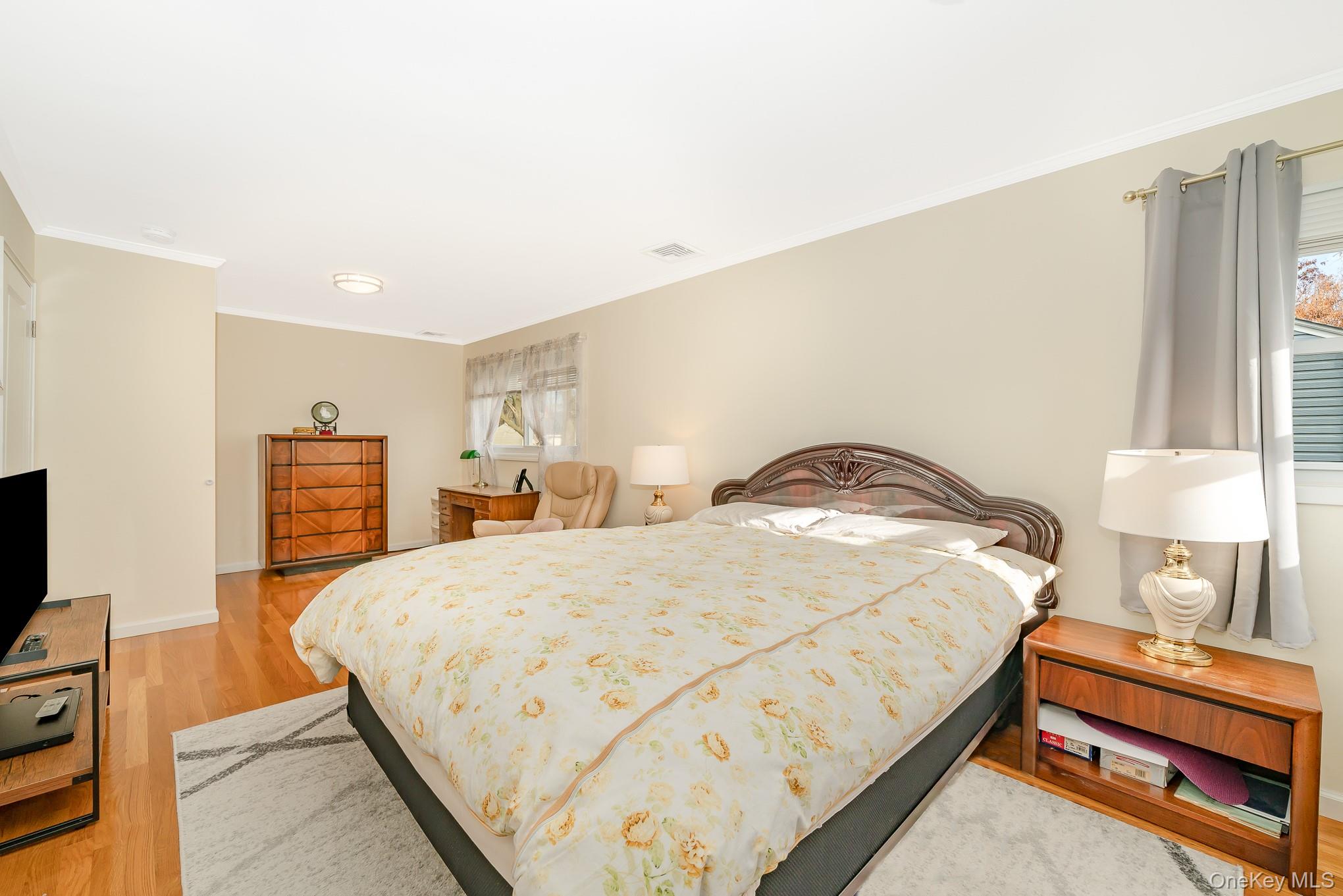 15 Chadwick Road Syosset, NY 11791 - Photo 26 of 35 a bedroom with a bed and a flat tv screen on dresser