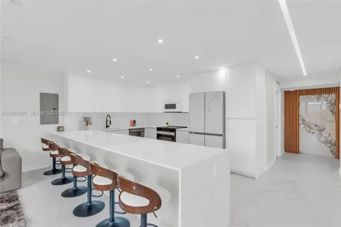 a kitchen with stainless steel appliances a sink a table and chairs