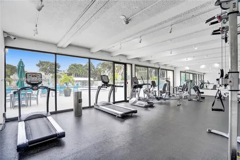 a view of a room with gym equipment and floor to ceiling window