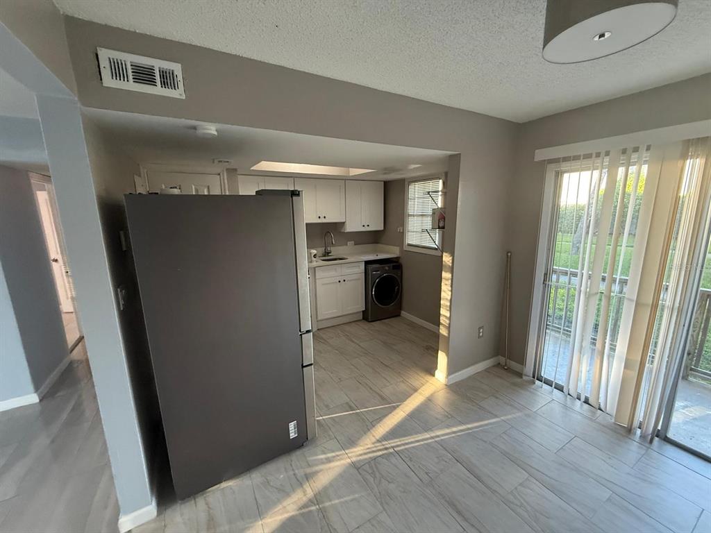 2787 L B McLeod Road, Unit 2787A Orlando, FL 32805 - Photo 18 of 34 a view of a kitchen with a refrigerator wooden floor and a window