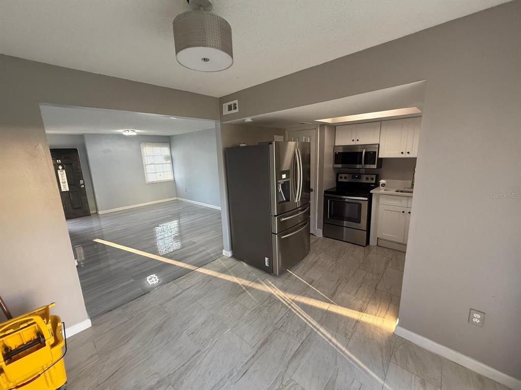 2787 L B McLeod Road, Unit 2787A Orlando, FL 32805 - Photo 19 of 34 a view of a kitchen with furniture and a refrigerator