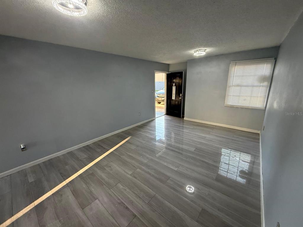 2787 L B McLeod Road, Unit 2787A Orlando, FL 32805 - Photo 23 of 34 a view of an empty room with wooden floor and a window