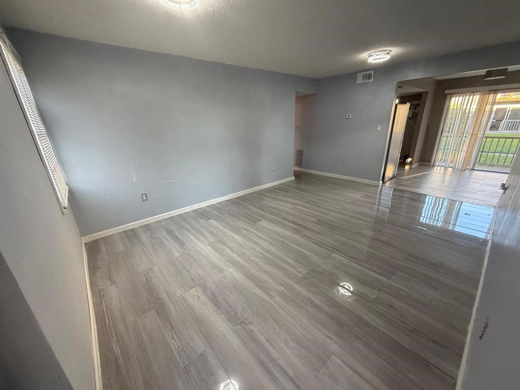 2787 L B McLeod Road, Unit 2787A Orlando, FL 32805 - Photo 6 of 34 wooden floor in an empty room with a window