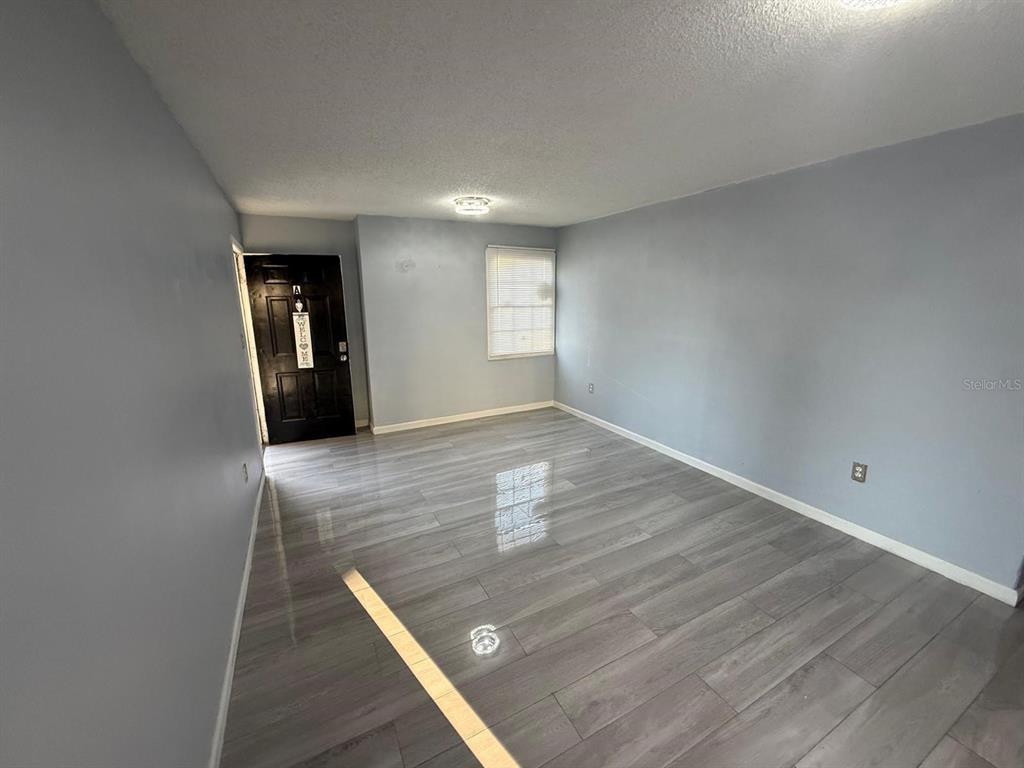 2787 L B McLeod Road, Unit 2787A Orlando, FL 32805 - Photo 7 of 34 an empty room with wooden floor and entrance