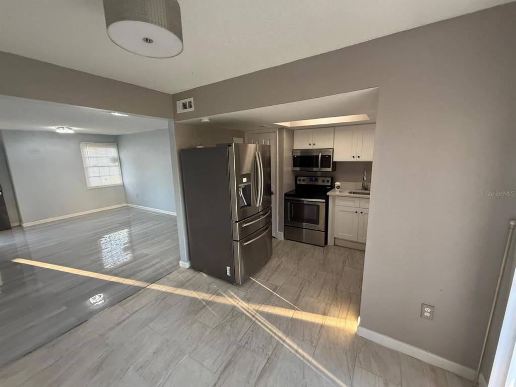 2787 L B McLeod Road, Unit 2787A Orlando, FL 32805 - Photo 8 of 34 a view of a kitchen with a sink and refrigerator