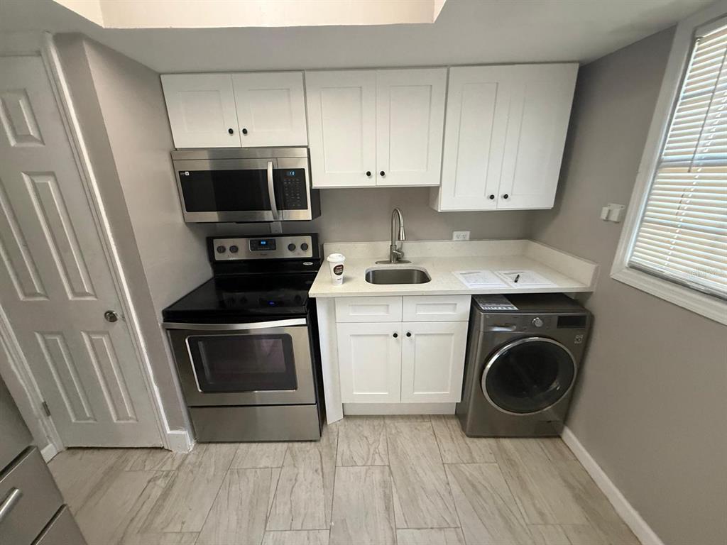 2787 L B McLeod Road, Unit 2787A Orlando, FL 32805 - Photo 10 of 34 a kitchen with a stove top oven and sink