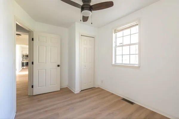 a view of an empty room with wooden floor