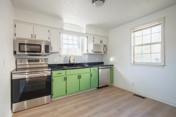 a kitchen with cabinets and a refrigerator