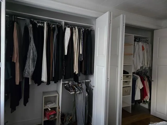 a view of walk in closet with clothes and shoes